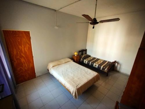 a bedroom with a bed and a ceiling fan at Casita Festiva in Santa María