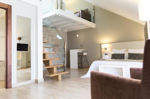 a bedroom with a bed and a staircase in a room at Tinas de Pechon in Pechón