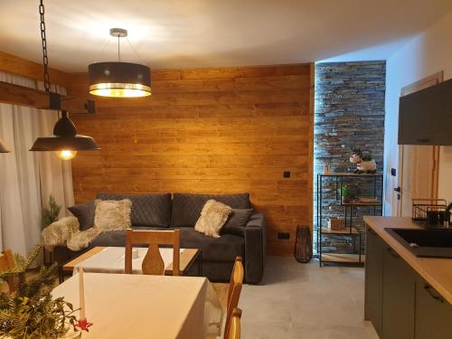 uma sala de estar com um sofá e uma mesa em Korona Pienin Domki & Apartamenty em Szczawnica