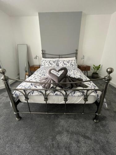 a bedroom with a bed with a heart pillow at Garden flat in 'Little Chelsea' in Eastbourne