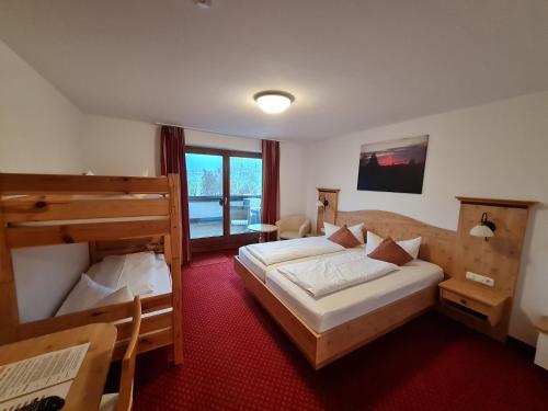 Cette chambre comprend 2 lits et une fenêtre. dans l'établissement Familienhotel Löwen, à Nesselwang