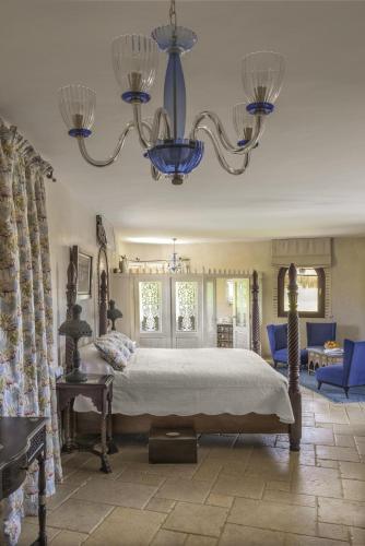a bedroom with a large bed and a chandelier at La Sultana Oualidia in Oualidia
