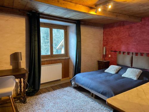 a bedroom with a blue bed and a window at La Combe de Moulin in Peisey-Nancroix
