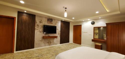 a bedroom with a bed and a tv on a wall at المبيت للشقق الفندقية in Sirr Āl Ghalīz̧