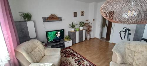 a living room with two chairs and a flat screen tv at Ferienwohnung Schwarz in Lauter
