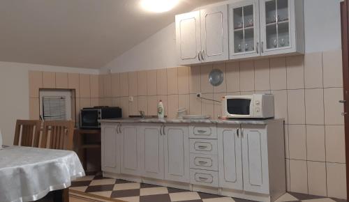 a kitchen with white cabinets and a microwave at LUX APARTMENT in Banja Luka