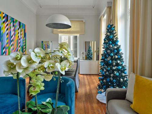 a living room with a blue christmas tree and a couch at The White House in Plaka by JJ Hospitality in Athens