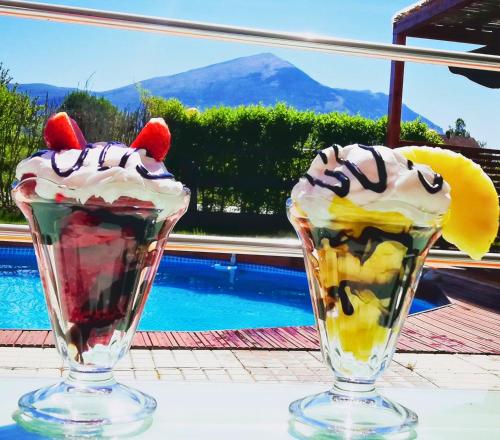 two milkshakes sitting on a table next to a pool at Villa Saturea in Boljevac