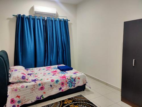 - une chambre avec un lit et un rideau bleu dans l'établissement Homestay Fayyadh Teluk Intan 3Room2Bath, à Teluk Intan