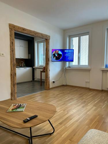 a living room with a table and a tv in it at Villa Verde - Cave del Predil in Cave del Predil