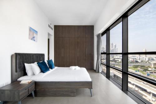 a bedroom with a bed and a large window at Sophisticated & Classy stay at The Onyx in Dubai