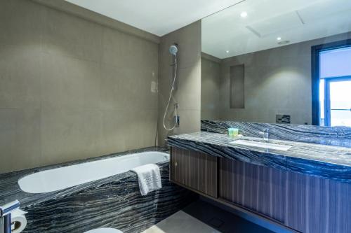 a bathroom with a tub and a sink at Sophisticated & Classy stay at The Onyx in Dubai