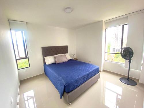 una camera da letto con un letto con un piumone blu e due finestre di Two bedroom apartment/Phenomenal views a Medellín