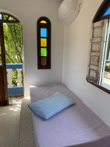a small room with a bed and a window at Cantinho dos Machados in Camaçari