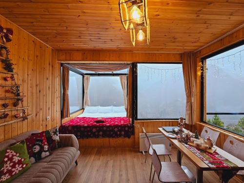 un soggiorno con letto in una camera con finestre di Villa Machakhela a Batumi