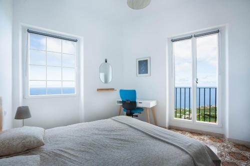 um quarto com uma cama, uma secretária e janelas em Cascada de Los Tilos with breathtaking views em Los Sauces