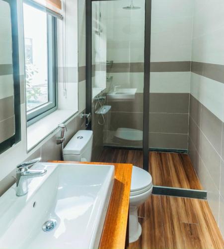 a bathroom with a white sink and a toilet at Chuỗi căn hộ Shan Apartment & Homestay - Vinhomes Imperia Hải Phòng in Hai Phong