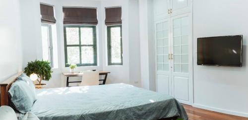 a bedroom with a bed and a flat screen tv at Chuỗi căn hộ Shan Apartment & Homestay - Vinhomes Imperia Hải Phòng in Hai Phong