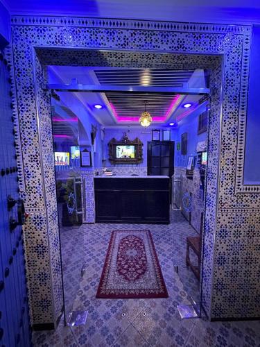 - une entrée à une pièce avec une scène et des lumières violettes dans l'établissement Maison d'hôtes Afassi, à Chefchaouen