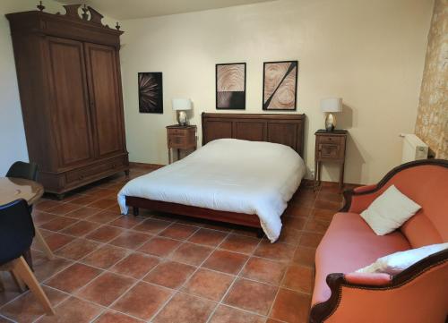 een slaapkamer met een bed en 2 stoelen. bij Chambre d'hôte la source in Conne-de-Labarde