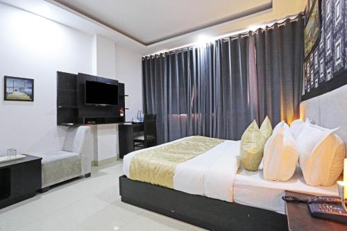 pokój hotelowy z łóżkiem i telewizorem w obiekcie Airport Hotel Swan Near Delhi Airport w Nowym Delhi