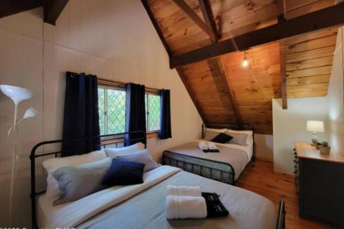 1 dormitorio con 2 camas en una habitación con techos de madera en 3 BR Centrally Located Poconos Chalet, en Tobyhanna