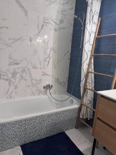 a bathroom with a tub and a shower curtain at Appartement "Laura" Terrasse - Parking - Plage in Juan-les-Pins