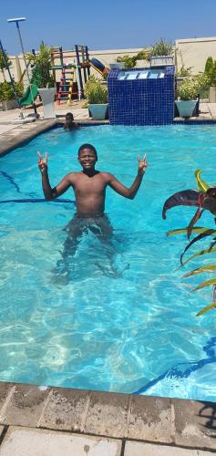 mężczyzna pływający w basenie w obiekcie Mpucuko Guest House w mieście Mtubatuba