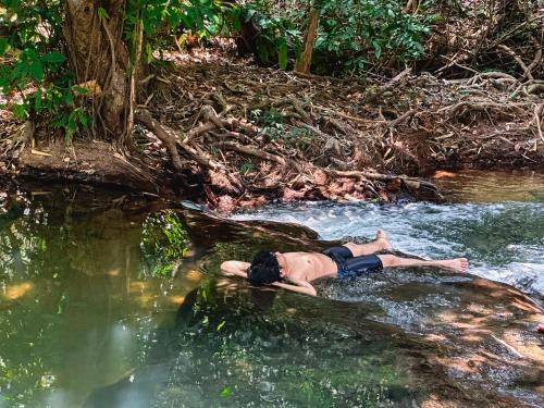 a man laying on a rock in a river at Ao Luek Homie Homestay in Krabi town