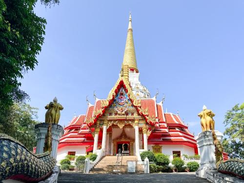 a pagoda with a steeple in front of a building at Ao Luek Homie Homestay in Krabi town