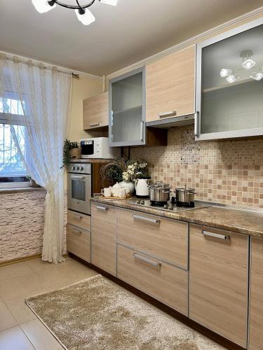 a kitchen with stainless steel appliances and a window at Центр Поруч озеро Наливайка 2 кімнати in Ternopilʼ