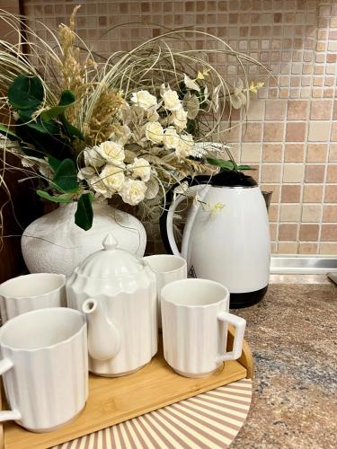 a group of white cups and vases on a counter at Центр Поруч озеро Наливайка 2 кімнати in Ternopilʼ