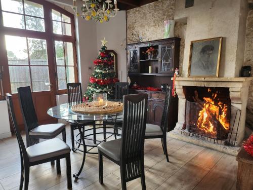 une salle à manger avec une table et un sapin de Noël dans l'établissement Maison chaleureuse et familiale., à Nalliers