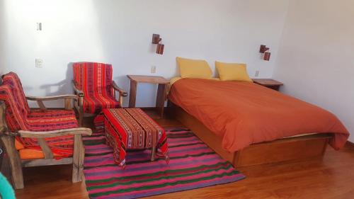 a bedroom with a bed and two chairs at CAMPO SANTO in Comunidad Yumani