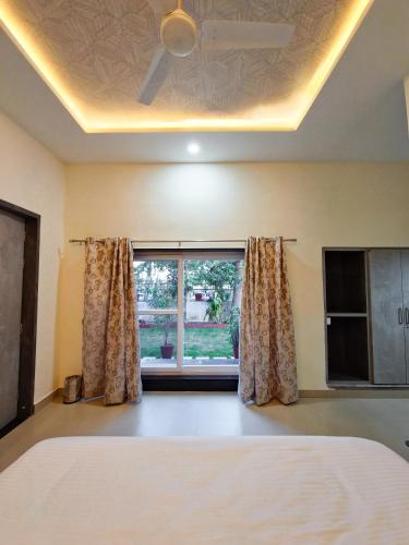 a bedroom with a bed and a window at Green Villa - Luxury Rooms at peaceful location -200 mtrs away from Bus Stand -500 mtrs from Udaipur Railway Station - Family Suites w Kitchen also available in Udaipur