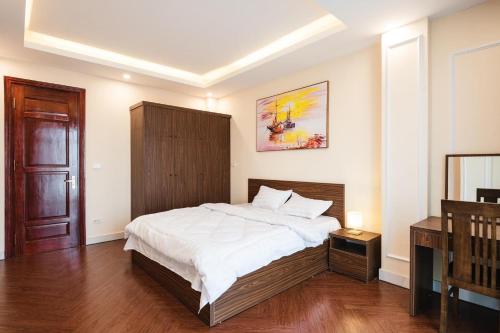 een slaapkamer met een groot bed met een houten hoofdeinde bij H2B WESTLAKE in Hanoi