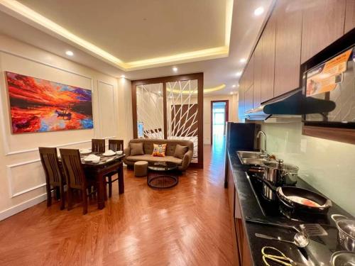 een keuken en een woonkamer met een tafel en een bank bij H2B WESTLAKE in Hanoi