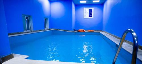 a blue room with a swimming pool with a blue wall at HAWADA PIONEER in Jeddah