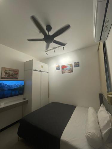 een slaapkamer met een bed en een plafondventilator bij Neu Suites Ampang in Kuala Lumpur