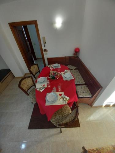ピエーヴェ・ディ・カドーレにあるVilla Naniの赤いテーブルクロスと椅子が備わる客室です。