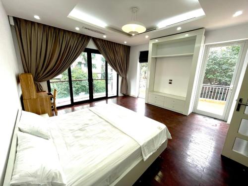 1 dormitorio con 1 cama grande y ventanas grandes en Cozy room close center and Ho Tay 671 p301, en Hanói