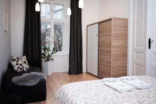 um quarto com uma cama, uma cadeira e um espelho em Apartment HYGGE em Subotica