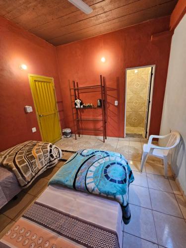 Cette chambre comprend un lit et deux portes. dans l'établissement Hotel Los Chow Chow, à Posadas