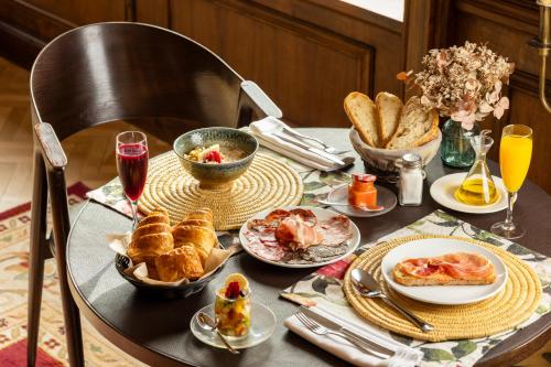 a table with plates of food and bread on it at Angelats Hotel - A Signature Boutique Hotel & Restaurant in Ribes de Freser