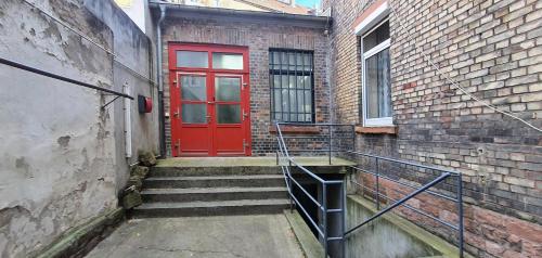 uma porta vermelha do lado de um edifício de tijolos em Helles Zimmer im Loft em Mannheim