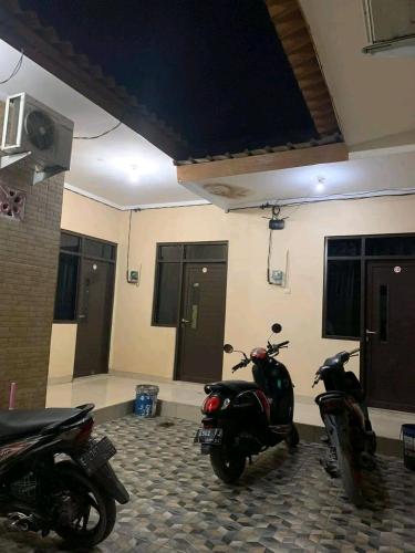 two motor scooters parked in a room at Pondok Kost Aurel 