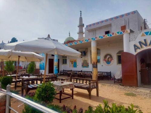 a restaurant with tables and umbrellas in front of it at ANA-KA in Aswan