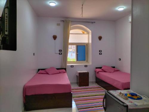 a room with two beds and a window at ANA-KA in Aswan