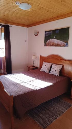 a bedroom with a large wooden bed in a room at Casa do Galvão -Turismo Rural - Serra da Estrela in Aguincho