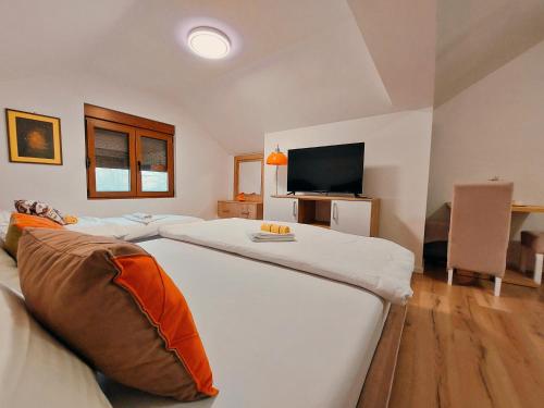 een slaapkamer met 2 bedden en een flatscreen-tv bij Buba Palace in Nikšić